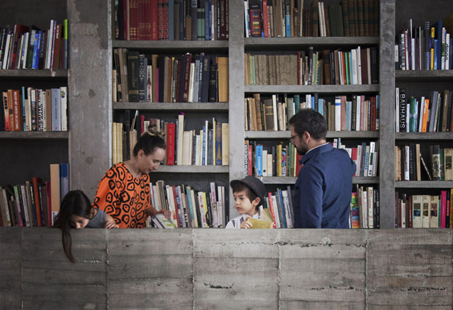 famille dans bibliothèque de béton brut